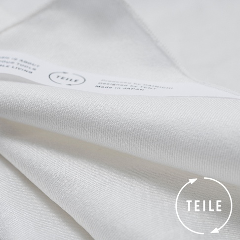 白色纖維擦拭巾，材質柔軟，織紋細膩。標籤印有「TEILE」品牌字樣及「Made in JAPAN」產地資訊，右下角有標示品牌名稱的圓形圖案。