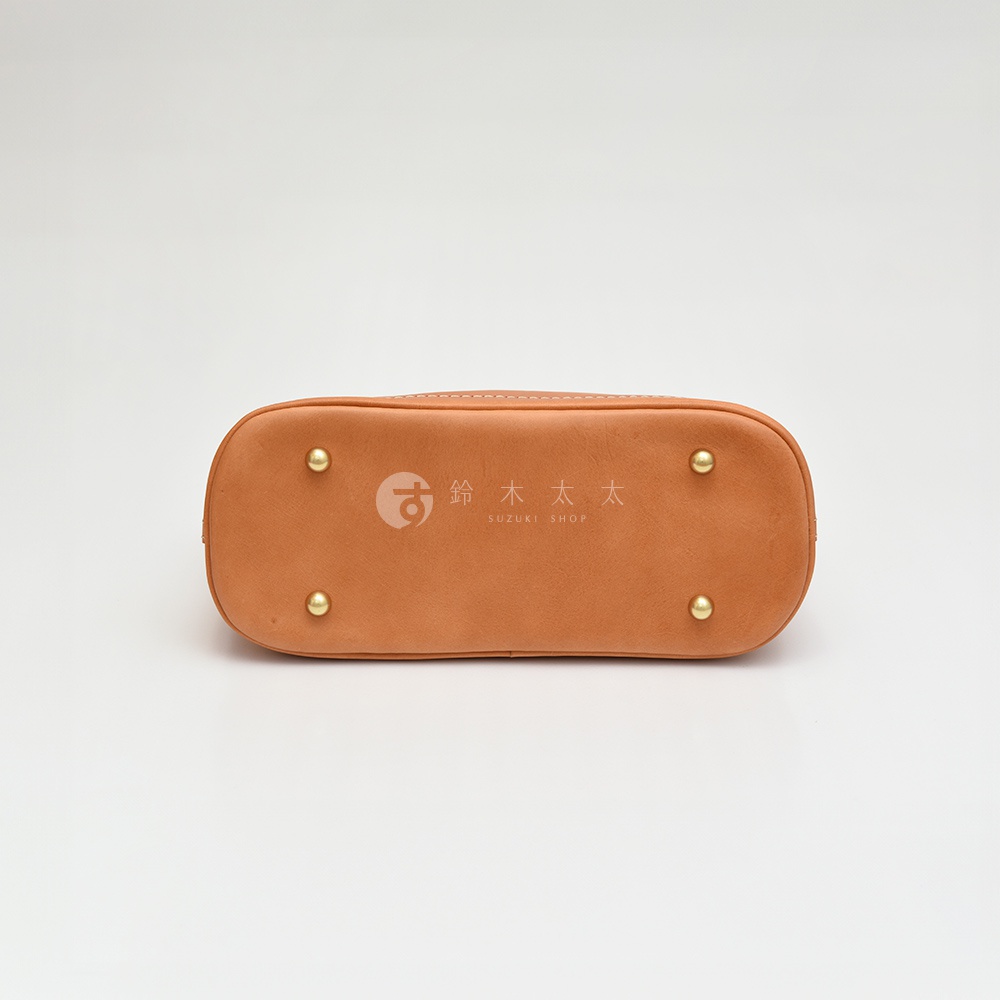 職人手作皮革兩用經典貝殼手提包，淺棕色皮革，底部有四個金色金屬腳釘，印有品牌標誌。