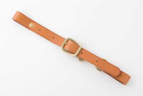 寬 3 公分的棕色皮革胸前扣帶，配有黃銅色扣環、調節孔和黃銅色按扣。