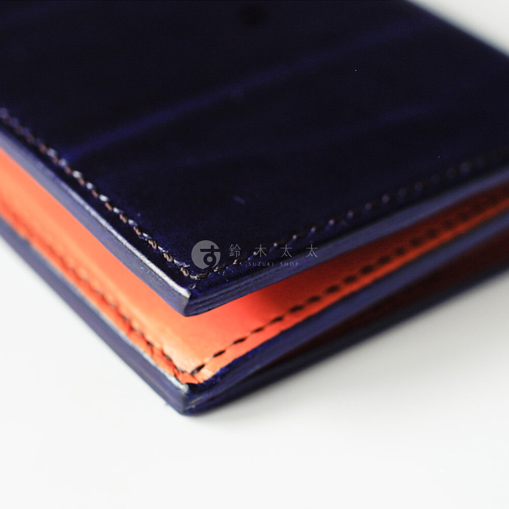 左側為午夜藍Rugato皮革，右側為橘棕色植鞣牛皮，邊緣縫線清晰可見，帶有SUZUKI SHOP的商標