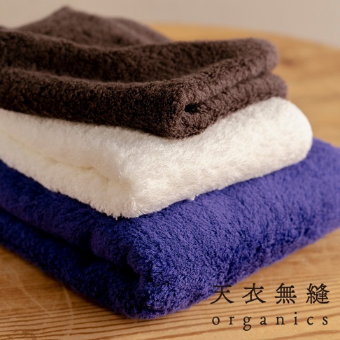 三條蓬鬆柔軟的長纖匹馬棉毛巾，依序堆疊，由上至下顏色為深棕色、白色和紫色。