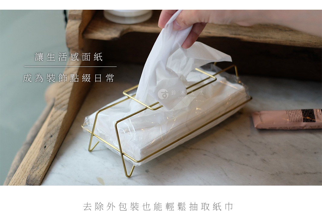 黃銅金屬質感收納面紙盒，內含一疊白色面紙，手正從盒中抽取一張面紙。