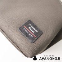 AYANOKOJI Sarei 京都職人手作Sarei機能布方形口金單肩包，包身為灰色織物材質，帶有品牌標籤，底部有中文品牌標識。