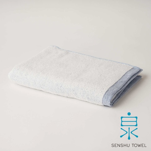 YUKINONE 雪之音柔織有機棉迷你浴巾，白色主體搭配淺藍色滾邊，材質柔軟。