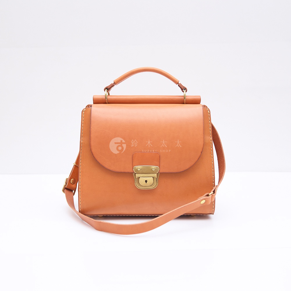 精緻手提斜背包，採用棕色皮革製作，配有金色鎖扣和肩帶