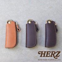 職人手作皮革Organ拉鍊鑰匙包，展示淺棕色、深棕色和深褐色的三種顏色，皆為皮革材質，配有金色拉鍊與掛環。