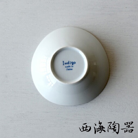白色圓形陶瓷小碟，底部有藍色「Indigo made in Japan」字樣，整體呈現簡潔素雅的風格。