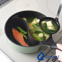 Arnest 雙鍋料理鍋，一邊是煎鮭魚和青辣椒，另一邊是味噌豆腐湯，湯勺正從湯鍋中舀起湯。