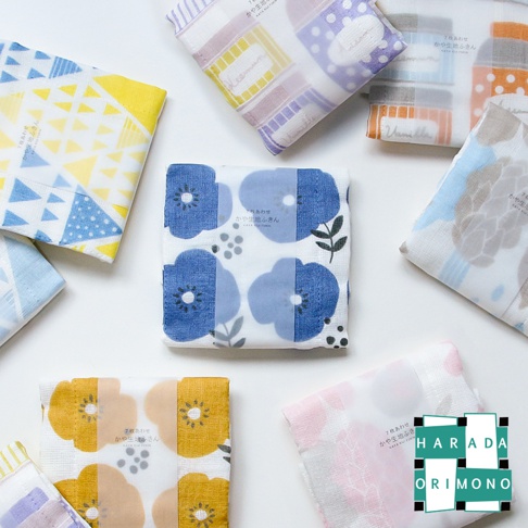 多款七層紗拭巾，印有藍色、黃色、粉色、紫色、橘色和灰色花朵與幾何圖案。