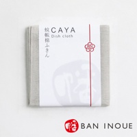 淺灰色紋理的蚊帳拭巾，以白色包裝紙包裹，印有「CAYA Dish cloth」字樣及紅色繩結裝飾。