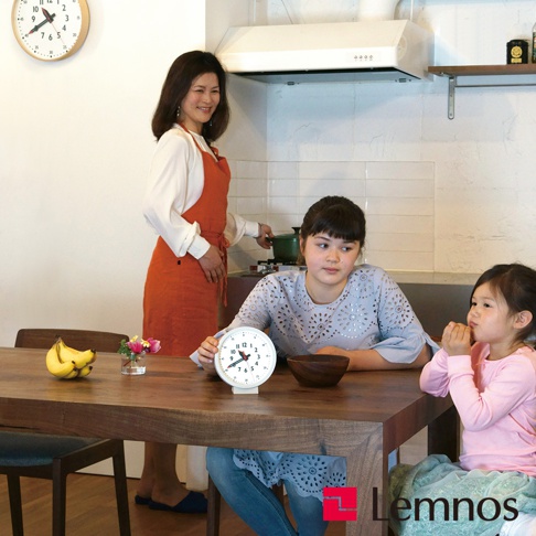 白色圓形桌面時鐘，帶有清晰的黑色數字和時針、分針、秒針，時鐘底座為白色。