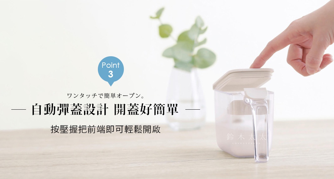 一隻手輕按透明調味料盒的握把前端，盒蓋隨即自動彈開。桌面擺放著這款白色調味料盒與一盆綠色植栽，強調一鍵即可輕鬆開啟的自動彈蓋設計。