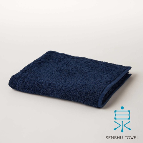 深藍色長纖毛巾，材質蓬鬆柔軟，表面帶有細緻的緞澤感，邊緣車縫整齊。