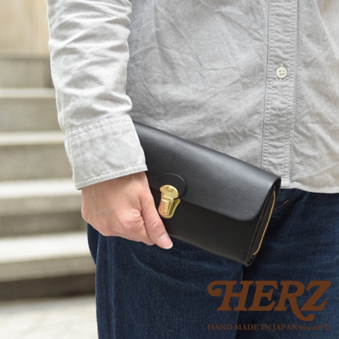 黑色皮革手風琴式長夾，配有金色鎖扣和拉鍊，由手工製作。