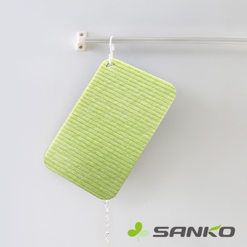 淺綠色帶有細緻紋路的迷你海綿洗衣板，側面有掛孔，正滴著水，懸掛在金屬桿上。