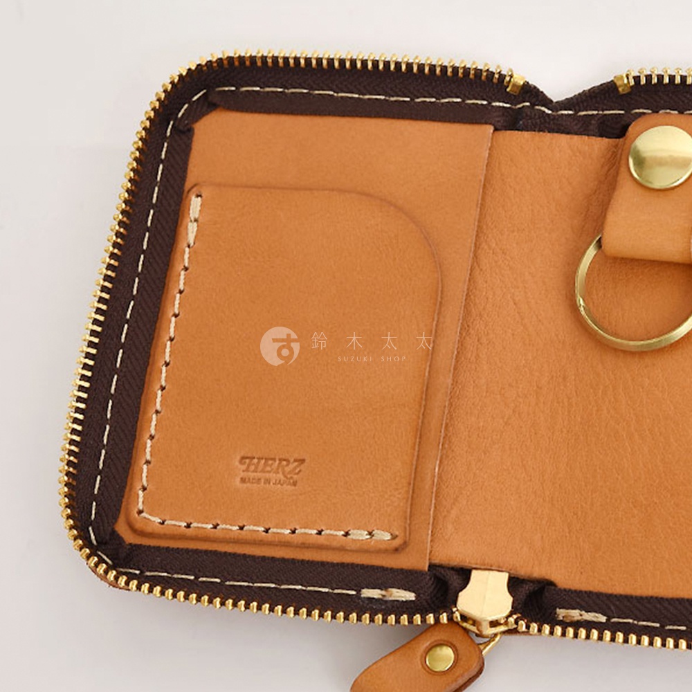 職人手作皮革多用途收納鑰匙包，露出內部結構。淺棕色皮革，設有卡槽、鑰匙圈和金色拉鍊，搭配深棕色縫線。