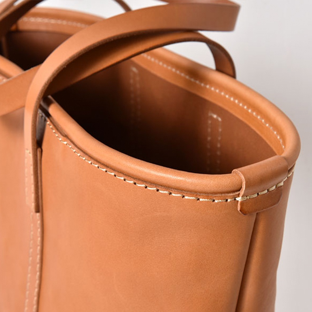 職人手作皮革經典托特包 T-9 L，採用天然棕色皮革製作，搭配手工縫線，展現精緻細節與質感。