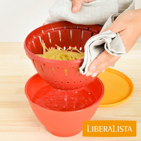 LIBERALISTA 瀝水籃組正在瀝乾剛煮好的義大利麵，其中一個紅色瀝水籃內裝有黃色的義大利麵，另一個紅色碗裡裝有水，背景是木質桌面。