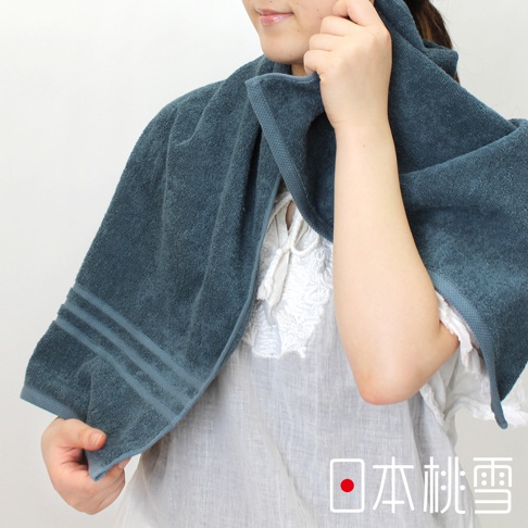 一件藍綠色今治飯店浴巾，質地柔軟，帶有三條同色系的壓紋裝飾。