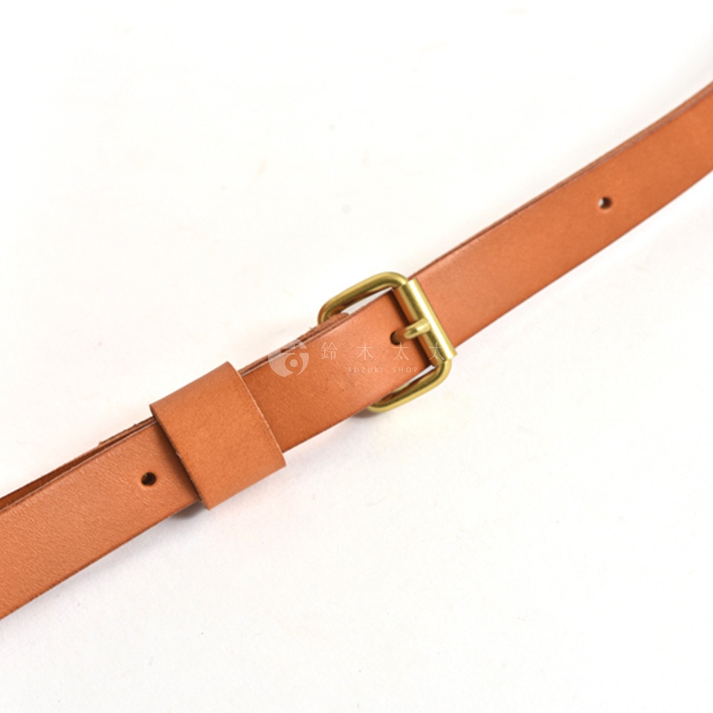 棕色皮革迷你托特包的肩帶，配有黃銅針扣和調節環，展現職人手作質感。