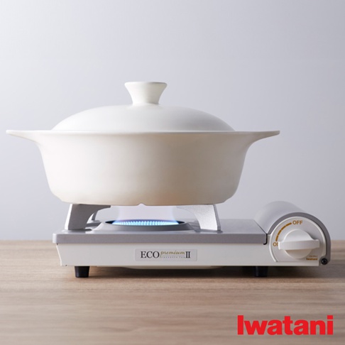 白色陶瓷鍋架在白色與灰色相間的瓦斯爐上，瓦斯爐中間燃燒著藍色火焰，爐身右側有標示「OFF」的旋鈕。