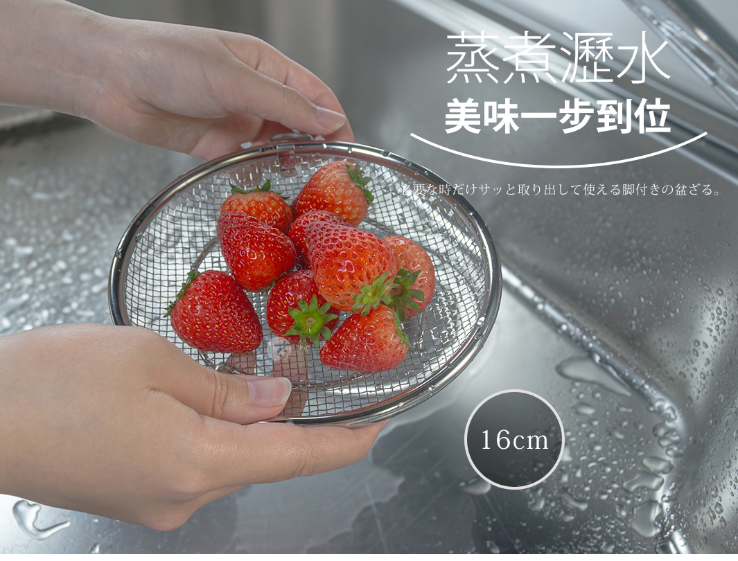 一雙手正捧著一個直徑 16 公分的柳宗理不鏽鋼瀝水盤，盤內放有數顆新鮮草莓，背景為不鏽鋼水槽，畫面右上方標示著蒸煮瀝水美味一步到位的日文短句。