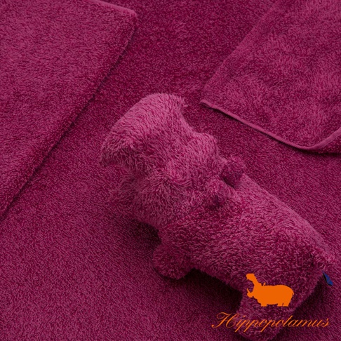 粉紅色竹棉混紡材質的河馬造型抓握玩偶，置於同色系織物上。