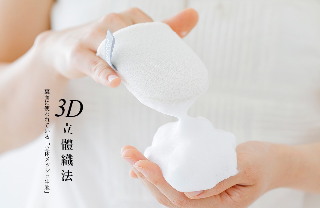 一隻手拿著白色蠶絲洗臉手套，手套上產生豐盈的白色泡沫，另一隻手接住泡沫。