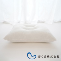 白色無敵軟枕，表面柔軟，中央有凹陷設計，材質看起來像絨布，背景為白色窗簾。