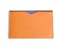 職人手作皮革存摺文件收納夾，採用淺棕色皮革製成，配有米白色縫線。收納夾內側可見紫色幾何圖案內襯。