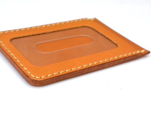 職人手作皮革直式票券收納夾，採用淺棕色皮革，車縫線為米白色。正面有一個透明視窗，可見內部皮革隔層。