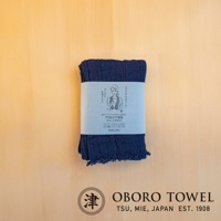 深藍色三層紗純棉掛脖毛巾，帶有簡約包裝紙，上面印有女性圖案和日文說明。