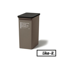 一個棕褐色的掀蓋式高版垃圾桶，配有黑色頂蓋。垃圾桶側面印有白色文字「Would you like to review what your life should be...?」及網址。
