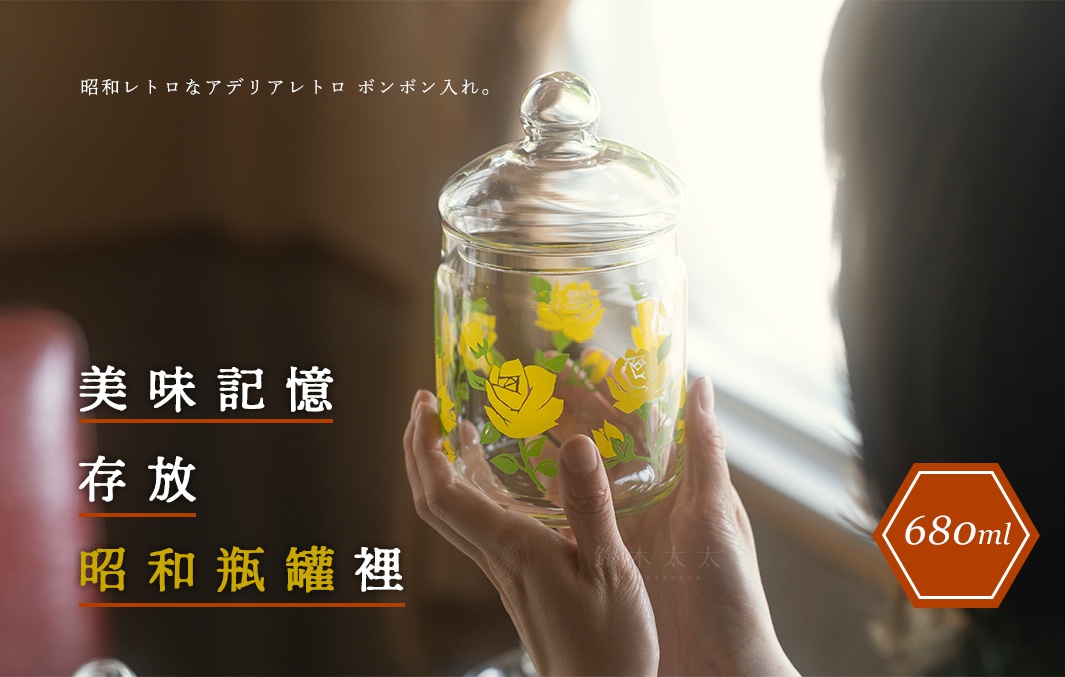 雙手捧著一個透明玻璃儲物罐，罐身印有黃色玫瑰圖案，罐蓋為圓球狀。