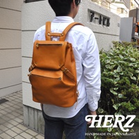 職人手作皮革多口袋後背包 R-135，呈現棕褐色，設有頂部翻蓋、雙拉鍊前袋和側邊扣帶，材質為皮革。