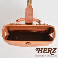 職人手作皮革迷你軟皮杜勒斯包，採用天然棕色皮革製成，頂部有提把和皮帶扣，內部有夾層和金色金屬扣。