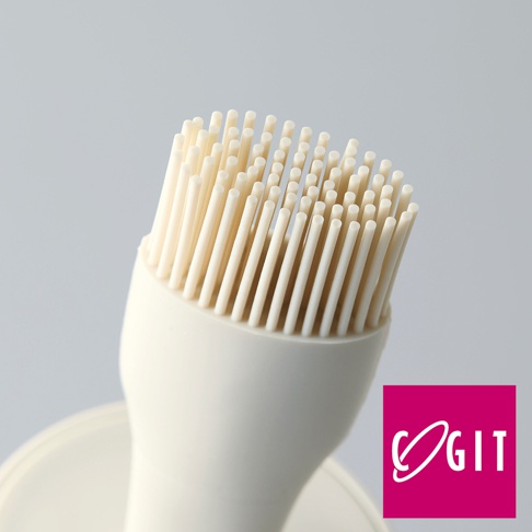 米白色矽膠油刷，刷毛密集，用於均勻塗抹醬料或油脂。