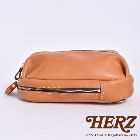 HERZ 品牌棕色皮革製作的立體運動斜背包，標有「HAND MADE IN JAPAN Since1973」字樣。