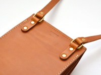 職人手作皮革厚實單肩包 (CP-61)，採用天然棕色皮革製成，帶有金屬扣環和可調節的皮革肩帶，包身縫線細緻，整體呈現簡約實用的風格。