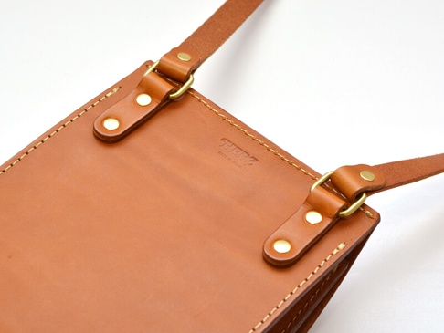 職人手作皮革厚實單肩包 (CP-61)，採用天然棕色皮革製成，帶有金屬扣環和可調節的皮革肩帶，包身縫線細緻，整體呈現簡約實用的風格。