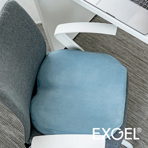 THE OWL 3D進階款坐墊，淺藍色，布面材質，放置於灰色辦公椅上，旁邊有白色扶手及筆記型電腦。