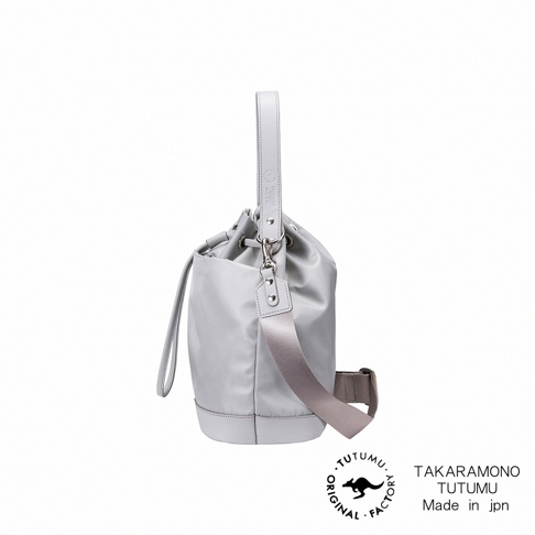 TUTUMU 兩用抽繩水桶包，灰色材質，搭配皮革提把和可調整斜背帶。
