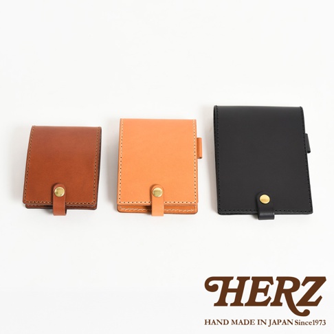 三款職人手作皮革便利貼收納套，分別為棕色、橘色和黑色，皆為牛皮材質，採用車縫線裝飾，並以金色釦環固定。