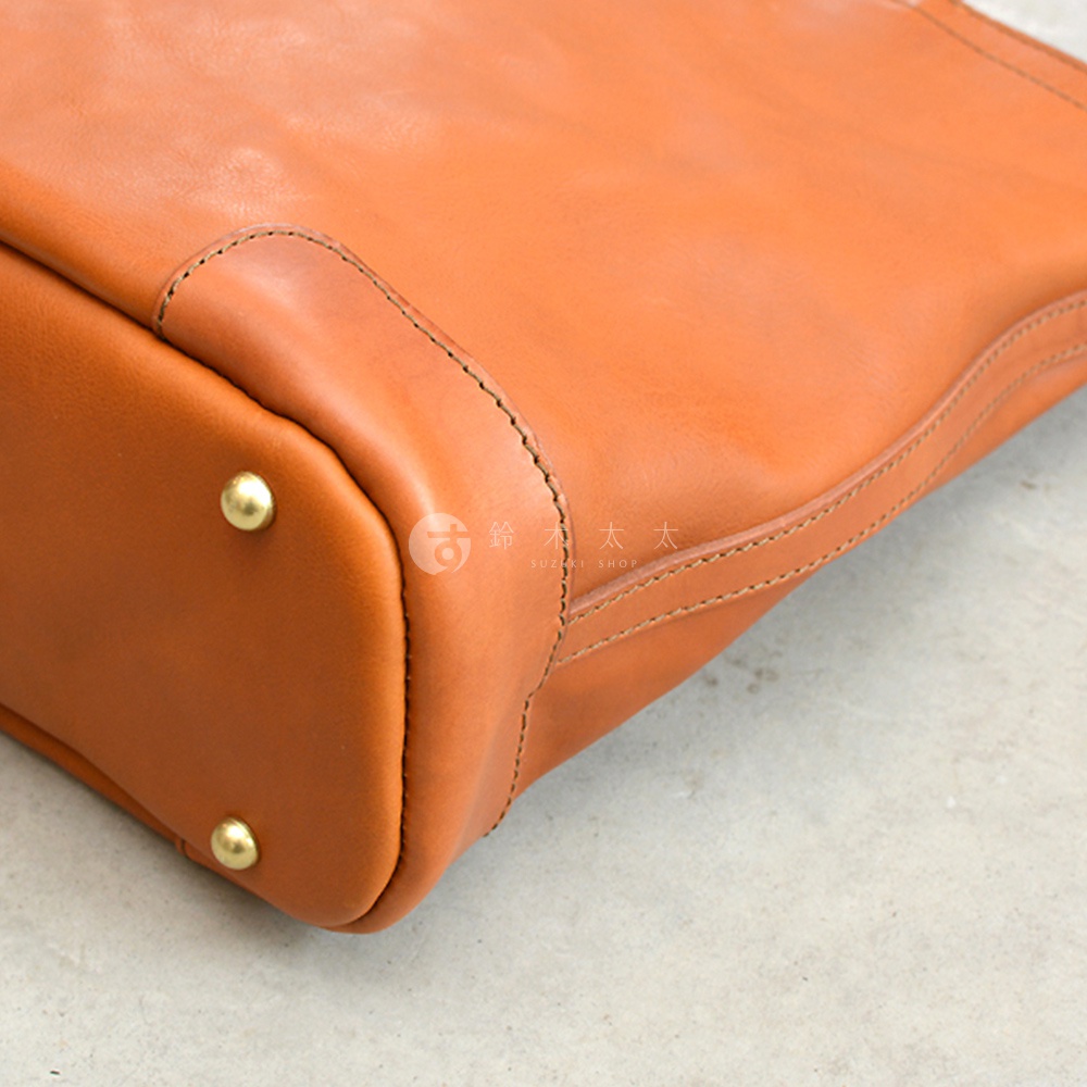 日本HERZ職人手作皮革Organ兩用拉鍊托特包 G-45 橘色款的細節，展示了包包角落的圓形金屬鉚釘和皮革縫線。