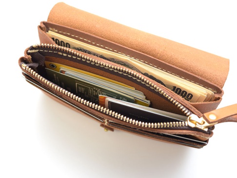 職人手作皮革旅行用多層次收納長夾，呈現自然棕色皮革質感，內部展示多層卡片夾層與紙鈔。