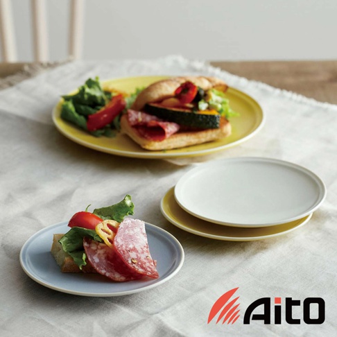 Ciel 美濃燒簡約素雅釉彩配菜盤，圖片展示一個淺藍色小圓盤，上面放著三明治配料，另一個黃色圓盤上放著一個三明治和沙拉，背景有兩個白色和黃色的盤子疊放。