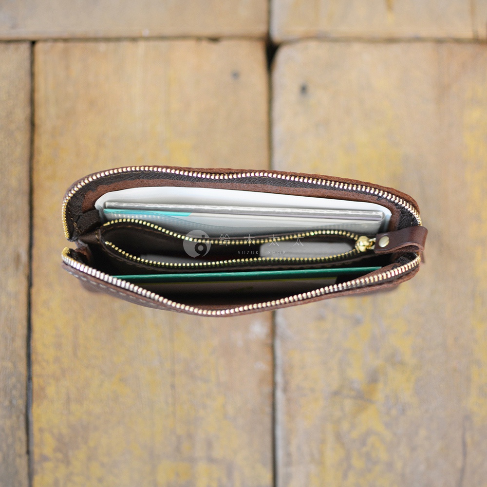 職人手作皮革Organ雙拉鍊收納袋，棕色皮革，內有文件、卡片等物品，拉鍊為金色。