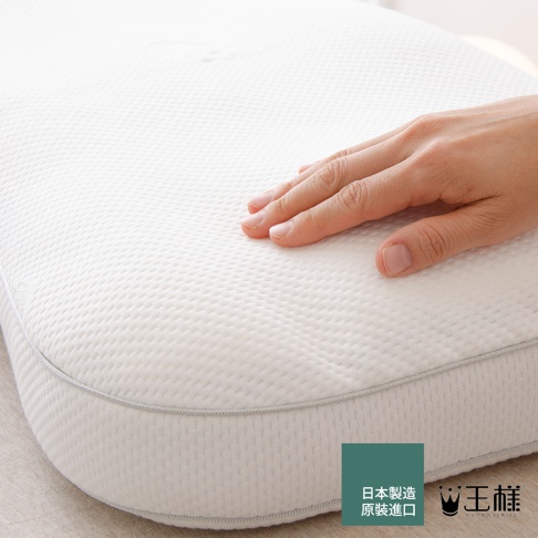 手輕壓白色天絲 TENCEL 枕套，枕面有細緻的紋理，枕頭邊緣以灰色滾邊縫製。