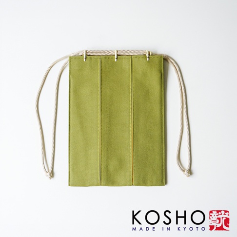 京都KOSHO品牌的一款ougi帆布信玄袋，外觀為清新的草綠色帆布材質，設計簡約俐落，袋身透過車縫線呈現出三等分結構，上方搭配米白色麻繩作為束口提把，整體風格呈現簡約且富有京都工藝質感，以正視角呈現於白色背景之上。