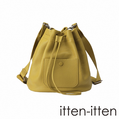 itten-itten 黃色荔枝紋皮革束口水桶包，正面有翻蓋口袋設計，搭配可調節背帶。